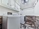 Laundry room featuring modern washer and dryer, white cabinets, and stone tile at 4271 Edgewater Drive Northwest Nw Dr, Kennesaw, GA 30144