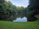 Scenic view of a peaceful pond surrounded by lush greenery and mature trees at 4271 Edgewater Drive Northwest Nw Dr, Kennesaw, GA 30144