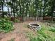 Backyard featuring a cozy fire pit and surrounded by lush greenery and a wooden fence at 4715 Scotney Ct, Suwanee, GA 30024