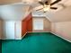 An attic bedroom featuring an accent wall, neutral color palette, and a ceiling fan at 4715 Scotney Ct, Suwanee, GA 30024