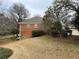 Brick house exterior with large yard and mature trees at 5005 Johns Creek Ct, Alpharetta, GA 30022