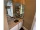 Home bar with sink, granite countertops, and mirrored shelving at 5005 Johns Creek Ct, Alpharetta, GA 30022