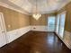 Elegant dining room with hardwood floors, wainscoting, chandelier, and natural light at 5005 Johns Creek Ct, Alpharetta, GA 30022