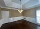 Elegant dining room featuring a tray ceiling, dark hardwood floors, and a chandelier for a luxurious feel at 5005 Johns Creek Ct, Alpharetta, GA 30022