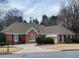 Charming brick home with a well-manicured lawn and mature trees at 5005 Johns Creek Ct, Alpharetta, GA 30022