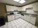 Kitchen features white appliances, cabinets, and tile flooring at 5005 Johns Creek Ct, Alpharetta, GA 30022