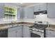 Bright kitchen featuring stainless steel appliances, gray cabinets, and laminate countertops at 8690 Cedar Creek Rdg, Riverdale, GA 30274