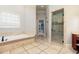 Luxurious bathroom features tile flooring, soaking tub, and glass-enclosed shower at 9695 Almaviva Dr, Alpharetta, GA 30022