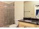Tiled bathroom featuring a walk-in shower with decorative tiles and a granite countertop vanity at 9695 Almaviva Dr, Alpharetta, GA 30022