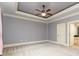 Large bedroom with tray ceiling, neutral walls, and plush carpeting at 9695 Almaviva Dr, Alpharetta, GA 30022