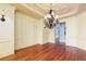 Open dining area with hardwood floors, modern chandelier and decorative wall trim at 9695 Almaviva Dr, Alpharetta, GA 30022
