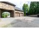 Large driveway leading to a multi-car garage with a basketball hoop at 9695 Almaviva Dr, Alpharetta, GA 30022