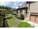 Brick home with a well-manicured backyard featuring landscaping and an attached garage at 9695 Almaviva Dr, Alpharetta, GA 30022