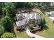 Expansive stone house with a winding driveway, lush lawn, and mature trees surrounding the property at 9695 Almaviva Dr, Alpharetta, GA 30022