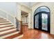 Elegant foyer with hardwood floors, curved staircase, and wrought iron railing at 9695 Almaviva Dr, Alpharetta, GA 30022