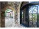 Close-up of the elegant arched entry with a wrought iron door and stone accents at 9695 Almaviva Dr, Alpharetta, GA 30022