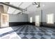 Bright garage featuring a checkered floor, white doors, windows and overhead storage racks at 9695 Almaviva Dr, Alpharetta, GA 30022