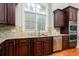 Kitchen showcasing custom cabinets, granite countertops, stainless appliances, tile backsplash and a window at 9695 Almaviva Dr, Alpharetta, GA 30022