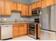 Kitchen with stainless steel appliances, wooden cabinets, and granite countertops at 9695 Almaviva Dr, Alpharetta, GA 30022
