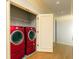 Laundry room with red washer and dryer units and tile flooring at 9695 Almaviva Dr, Alpharetta, GA 30022