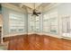 Well-lit living area with hardwood floors, fireplace, ceiling fan, and large windows offers great views at 9695 Almaviva Dr, Alpharetta, GA 30022
