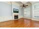 Bright living area showcases hardwood floors, stone fireplace, built-in cabinets, and large windows at 9695 Almaviva Dr, Alpharetta, GA 30022