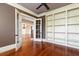 Comfortable den with hardwood floors, built-in shelving, French doors, and crown molding at 9695 Almaviva Dr, Alpharetta, GA 30022