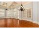 Expansive living room offers hardwood floors, coffered ceiling, chandelier lighting, and large windows at 9695 Almaviva Dr, Alpharetta, GA 30022