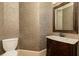Elegant powder room features patterned wallpaper, vanity with marble countertop, and decorative mirror at 9695 Almaviva Dr, Alpharetta, GA 30022