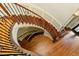 Ornate wooden staircase with decorative iron railings and hardwood flooring, creating a grand entrance at 9695 Almaviva Dr, Alpharetta, GA 30022
