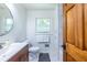 Bright bathroom features a modern vanity, round mirror, and a window with natural light at 1393 Sagewood Cir, Stone Mountain, GA 30083