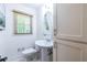 Compact bathroom with white fixtures, a pedestal sink, and bright natural light at 1393 Sagewood Cir, Stone Mountain, GA 30083
