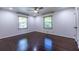 Spacious bedroom with hardwood floors, a ceiling fan, and natural light from two windows at 1393 Sagewood Cir, Stone Mountain, GA 30083