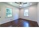 Bright bedroom with hardwood floors, a ceiling fan, and two large windows at 1393 Sagewood Cir, Stone Mountain, GA 30083