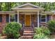 Charming brick home featuring a bright yellow front door, perfect landscaping, and covered porch at 1393 Sagewood Cir, Stone Mountain, GA 30083