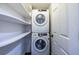 Conveniently located laundry area with modern stackable washer and dryer and built-in shelving at 1393 Sagewood Cir, Stone Mountain, GA 30083