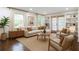 Bright living room featuring a neutral sectional sofa, hardwood floors, built-in shelves, and natural light at 1393 Sagewood Cir, Stone Mountain, GA 30083