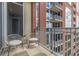 Relaxing balcony seating and a view of the building's red brick facade and expansive windows at 1820 Peachtree Nw St # 804, Atlanta, GA 30309