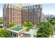 Luxury high-rise apartment building featuring a rooftop pool, lush landscaping, and views of the city skyline at 1820 Peachtree Nw St # 804, Atlanta, GA 30309