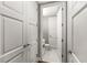 Hallway with closet that leads to an all-white bathroom featuring tile flooring and modern fixtures at 1820 Peachtree Nw St # 804, Atlanta, GA 30309