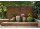 Tranquil garden water feature with large decorative pots against a brick wall at 1820 Peachtree Nw St # 804, Atlanta, GA 30309