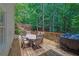 Outdoor deck with table, chairs, grill, and a view of the surrounding trees at 2045 Barrett Downs Dr, Cumming, GA 30040