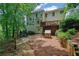 Enjoy the lush, wooded backyard with a charming playhouse, deck and stone patio at 2045 Barrett Downs Dr, Cumming, GA 30040