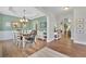 Open dining room with hardwood floors, a chandelier, and green walls, creating an inviting atmosphere at 2045 Barrett Downs Dr, Cumming, GA 30040