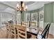 Open dining room featuring a large table, hardwood floors, and windows overlooking the yard at 2045 Barrett Downs Dr, Cumming, GA 30040