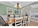 Dining room showcasing a large table, chandelier, and view into playroom with french doors at 2045 Barrett Downs Dr, Cumming, GA 30040