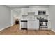 Bright kitchen with stainless steel appliances, white cabinets, and a view into the living room at 2045 Barrett Downs Dr, Cumming, GA 30040