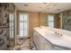 Bright bathroom featuring a double vanity, large mirror, marble floors and marble shower with gold trim at 2769 Peachtree Ne Rd # 7, Atlanta, GA 30305