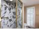 Marble tiled shower with gold trim and glass door, along with windowed toilet in bathroom at 2769 Peachtree Ne Rd # 7, Atlanta, GA 30305