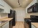 The kitchen has ample storage with laminate countertops and black appliances at 907 Olde Mill Ln, Norcross, GA 30093